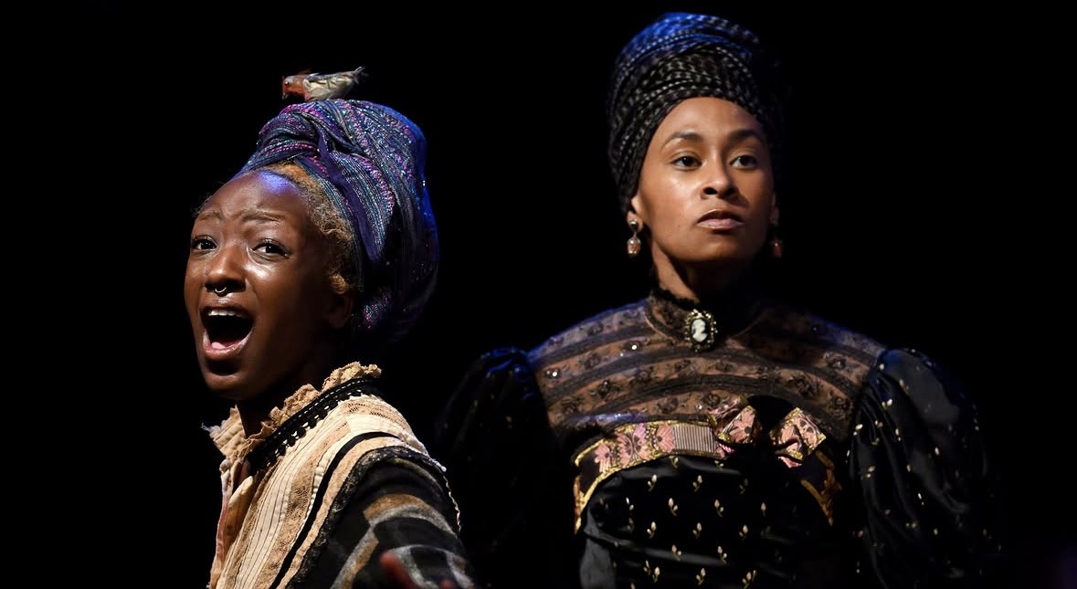Two performers in costume during a stage scene